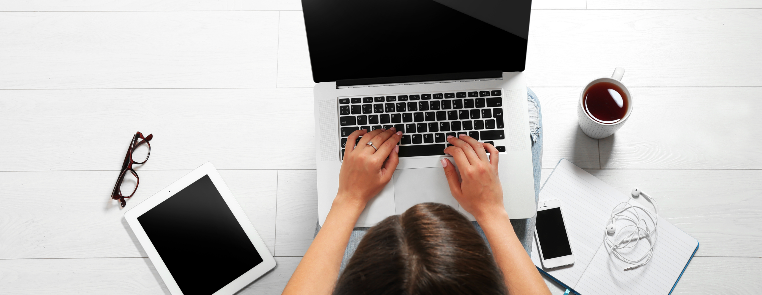 Woman on laptop with tablet and phone